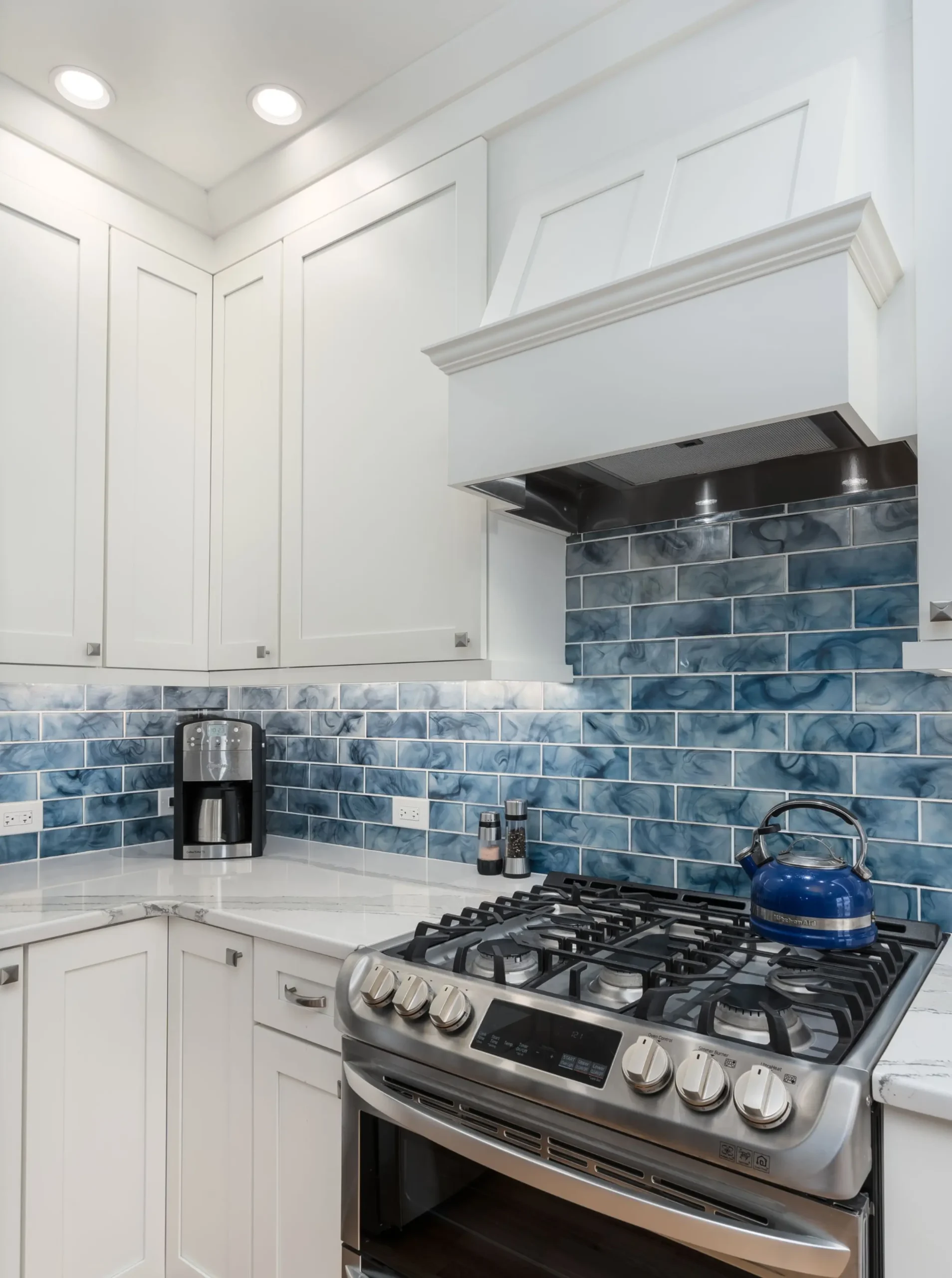 Subway tile backsplash and stainless steel range in modern kitchen design