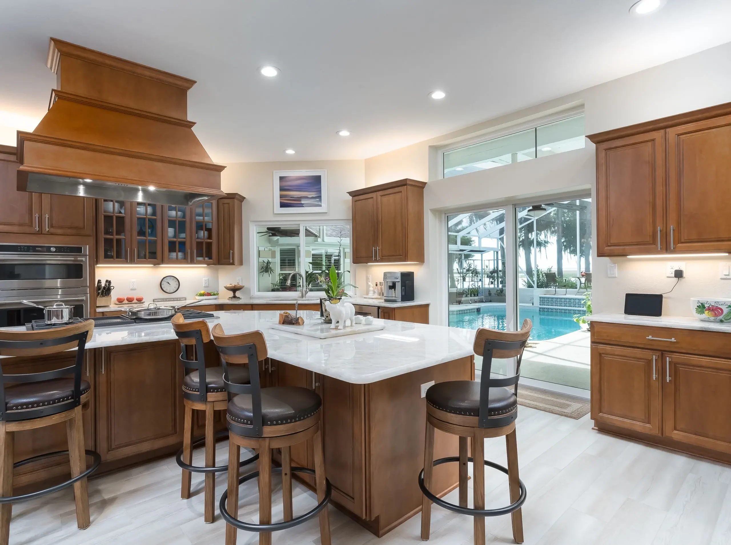 Traditional kitchen design with kitchen island and seating, looking into pool room