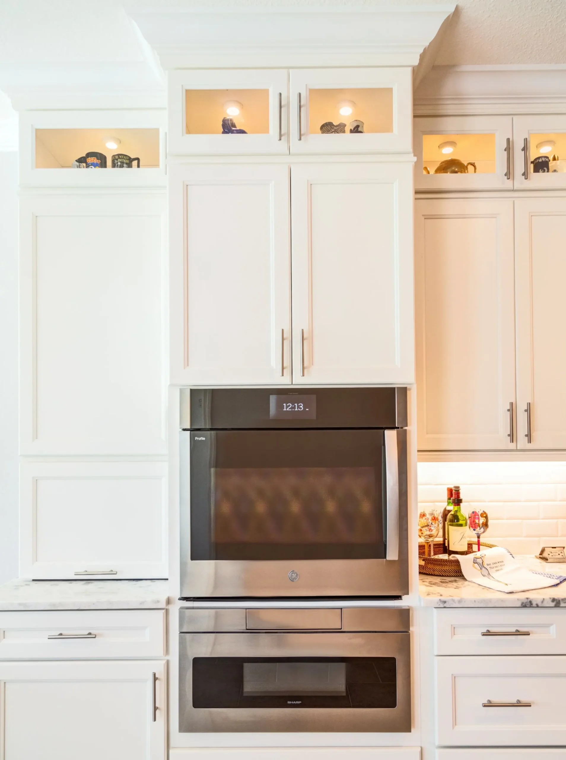 white kitchen cabinet design with wall oven and microwave