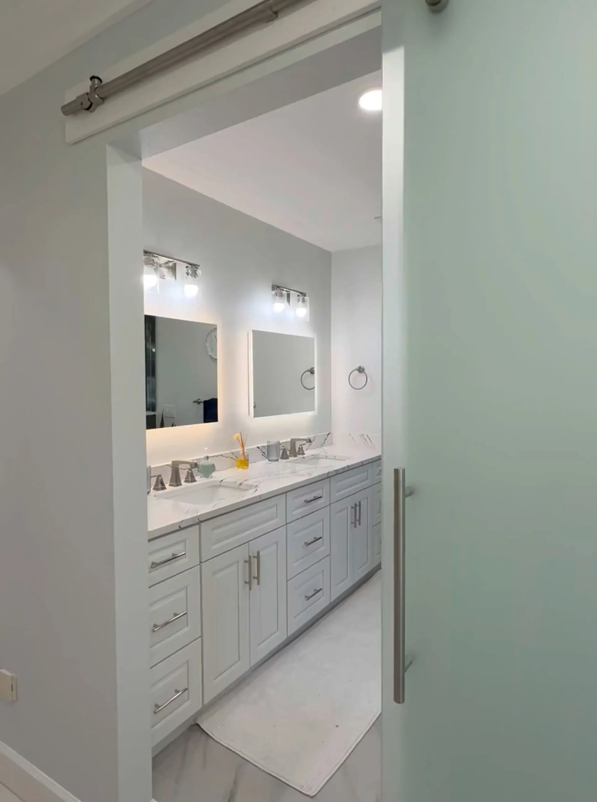 white bathroom with frosted glass barn door