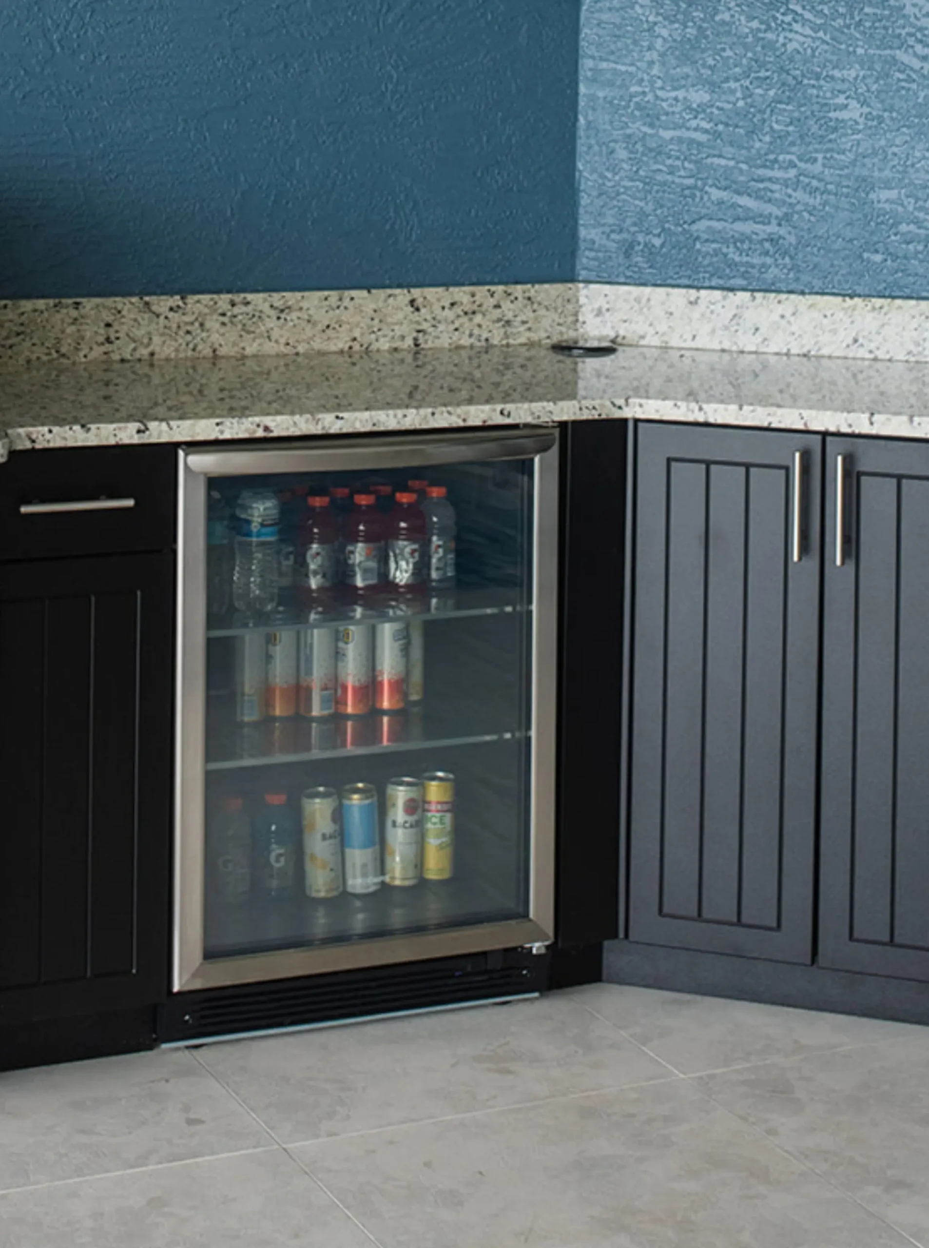 outdoor beverage refrigerator filled with drinks in outdoor kitchen