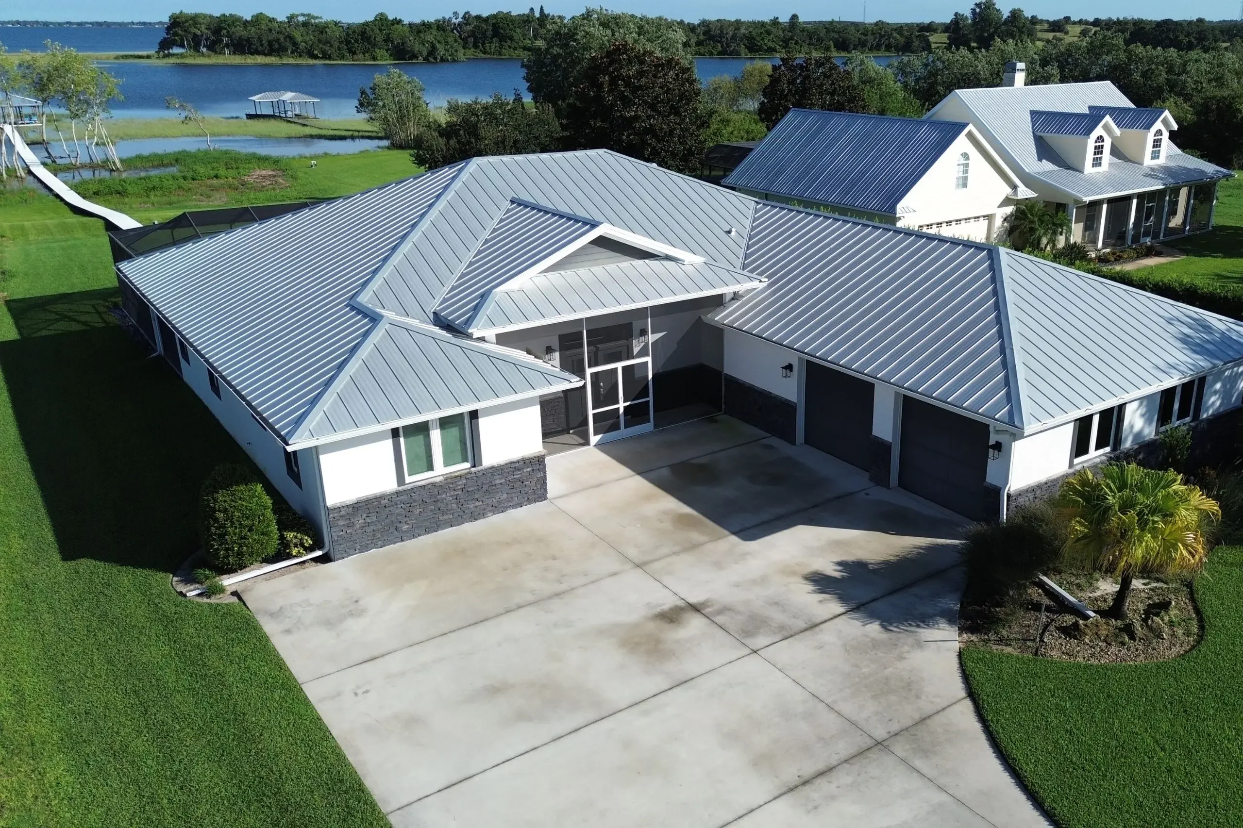 custom home with a metal roof built next to a lake 