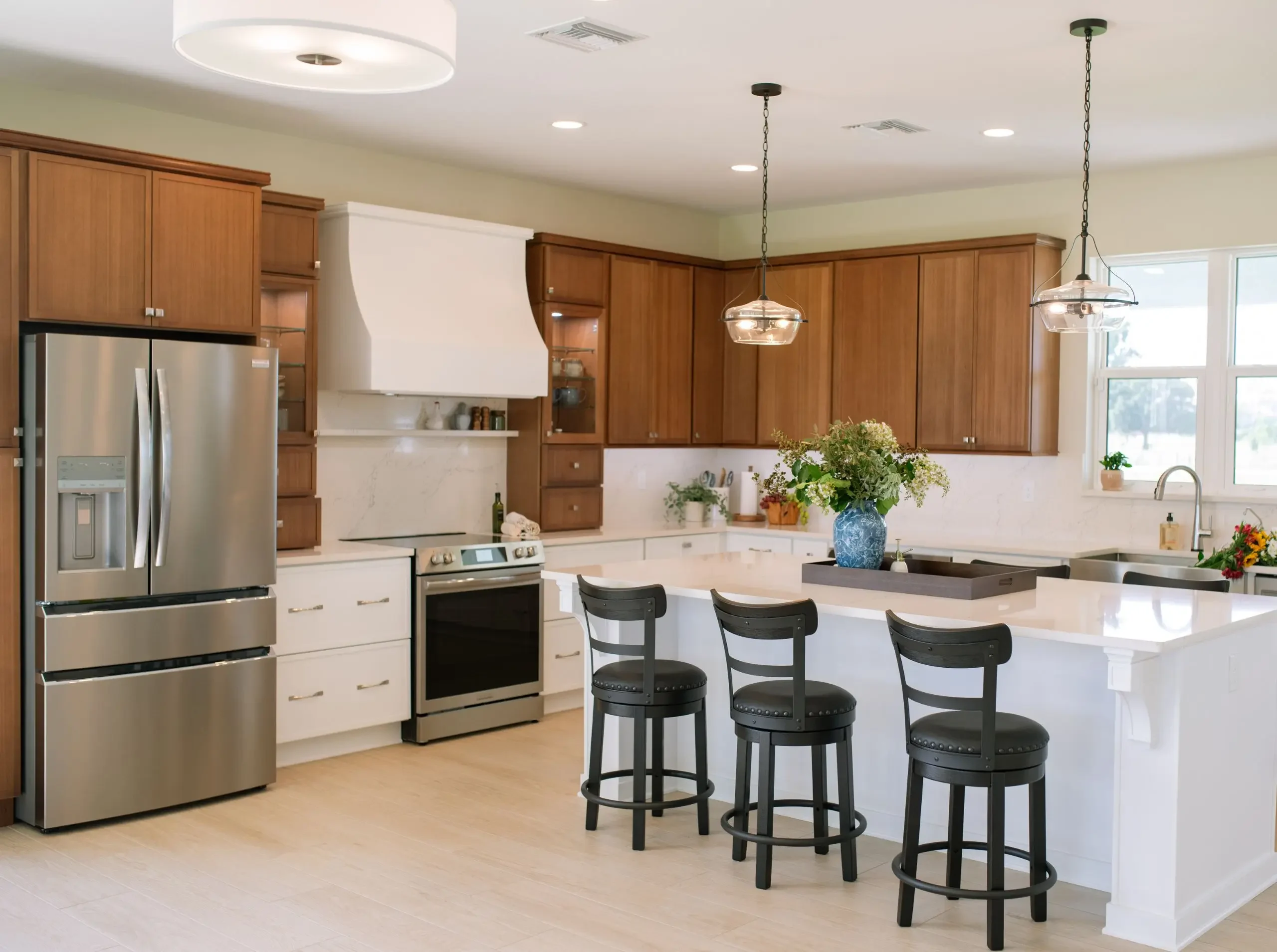 U-shaped kitchen with white lower cabinets, wood upper cabinets, and a central island
